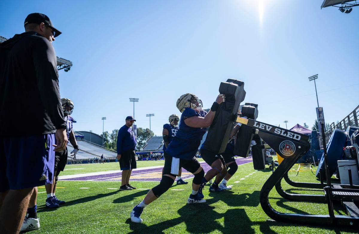 University of Washington Huskies offensive lineman Corey Luciano, 74, shoves a blocking pad during a drill on the fourth day of Fall practice at Husky Stadium on Thursday, Aug. 7, 2022 in Seattle, Wash.