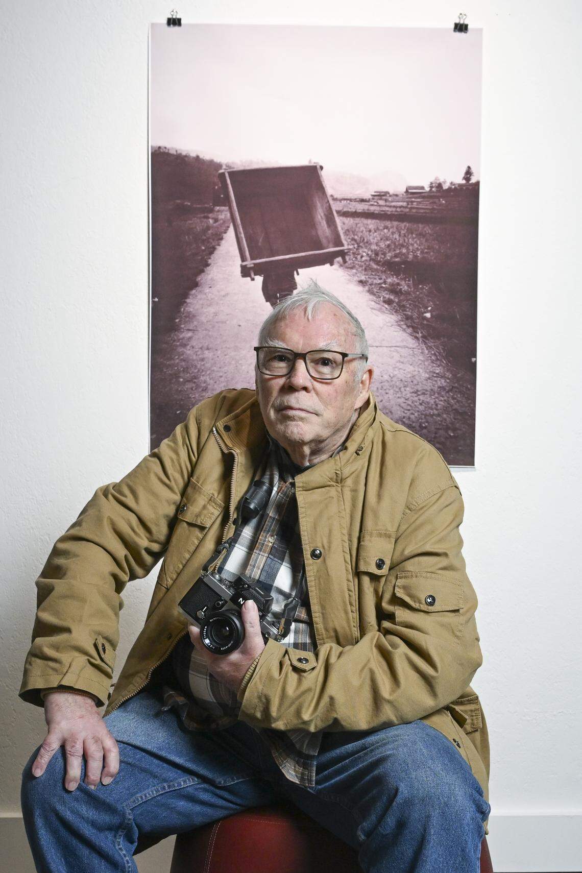 Richard Baker sits for a portrait in front of one of his own works being shown at The Tobin Gallery on Tuesday, Jan. 20, 2026, in Tacoma, Wash. The exhibit, “Richard Baker 50 Year Photography Retrospective,” is a show honoring the seasoned photographer’s lifetime of capturing moments.