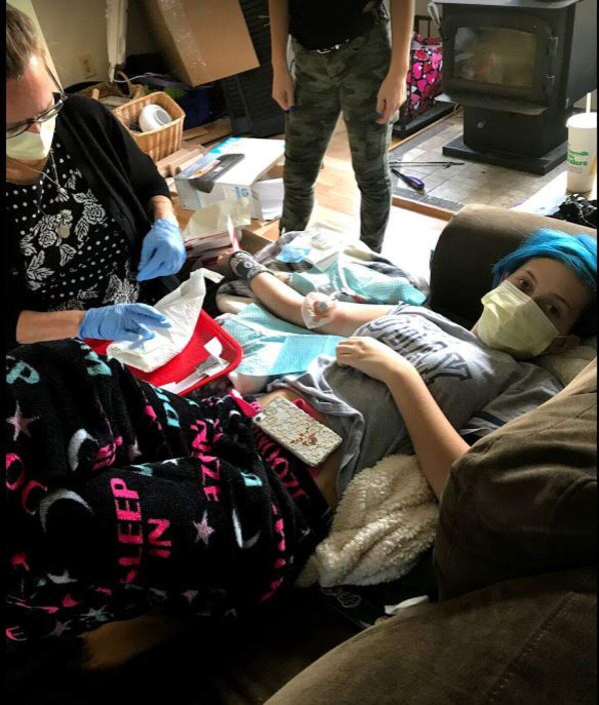 Hailee Hutton, 14, sits at home while a nurse helps her take immunotherapy medication. In October, 2017, Hailee was diagnosed with a rare condition, Severe Aplastic Anemia, which means her bone marrow fails to create enough blood cells for her to survive.