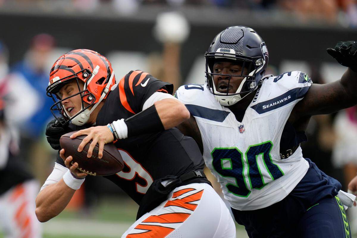 Cincinnati Bengals quarterback Joe Burrow (9) is sacked by Seattle Seahawks’ Jarran Reed (90) during the second half of an NFL football game, Sunday, Oct. 15, 2023, in Cincinnati. (AP Photo/Michael Conroy)