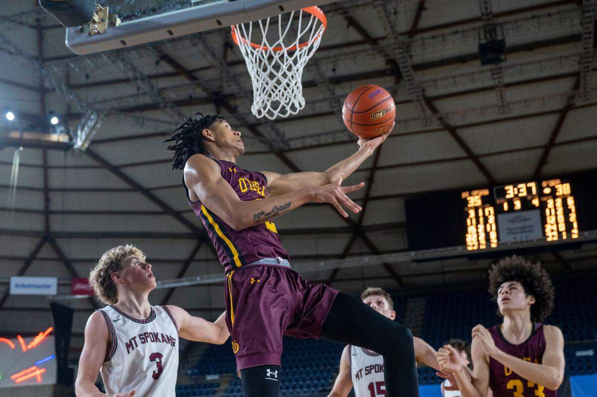O’Dea guard Mason Williams (2) goes in for a reverse layup as Mount Spokane guard Jake Moore (3) looks on during the third quarter of a Class 3A semifinal game on Friday, March 3, 2023, in Tacoma, Wash.