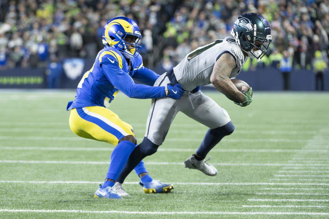 Los Angeles Rams cornerback Darious Williams (31) grabs hold of Seattle Seahawks wide receiver Jaxon Smith-Njigba (11) in the second half of the game at Lumen Field, on Thursday, Dec. 18, 2025, in Seattle.