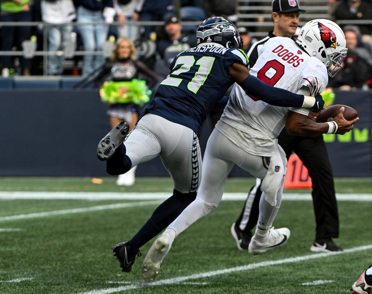 Seattle Seahawks cornerback Devon Witherspoon (21) sacks Arizona Cardinals quarterback Joshua Dobbs (9) before a defensive foul is called during the fourth quarter of the game at Lumen Field, Sunday, Oct. 22, 2023, in Seattle, Wash.