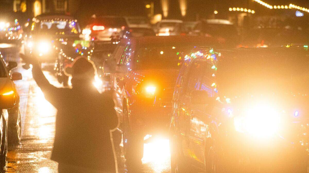 Decorated cars drive by Skansie Brothers park during a lighted holiday parade in downtown Gig Harbor on Dec. 19, 2020.