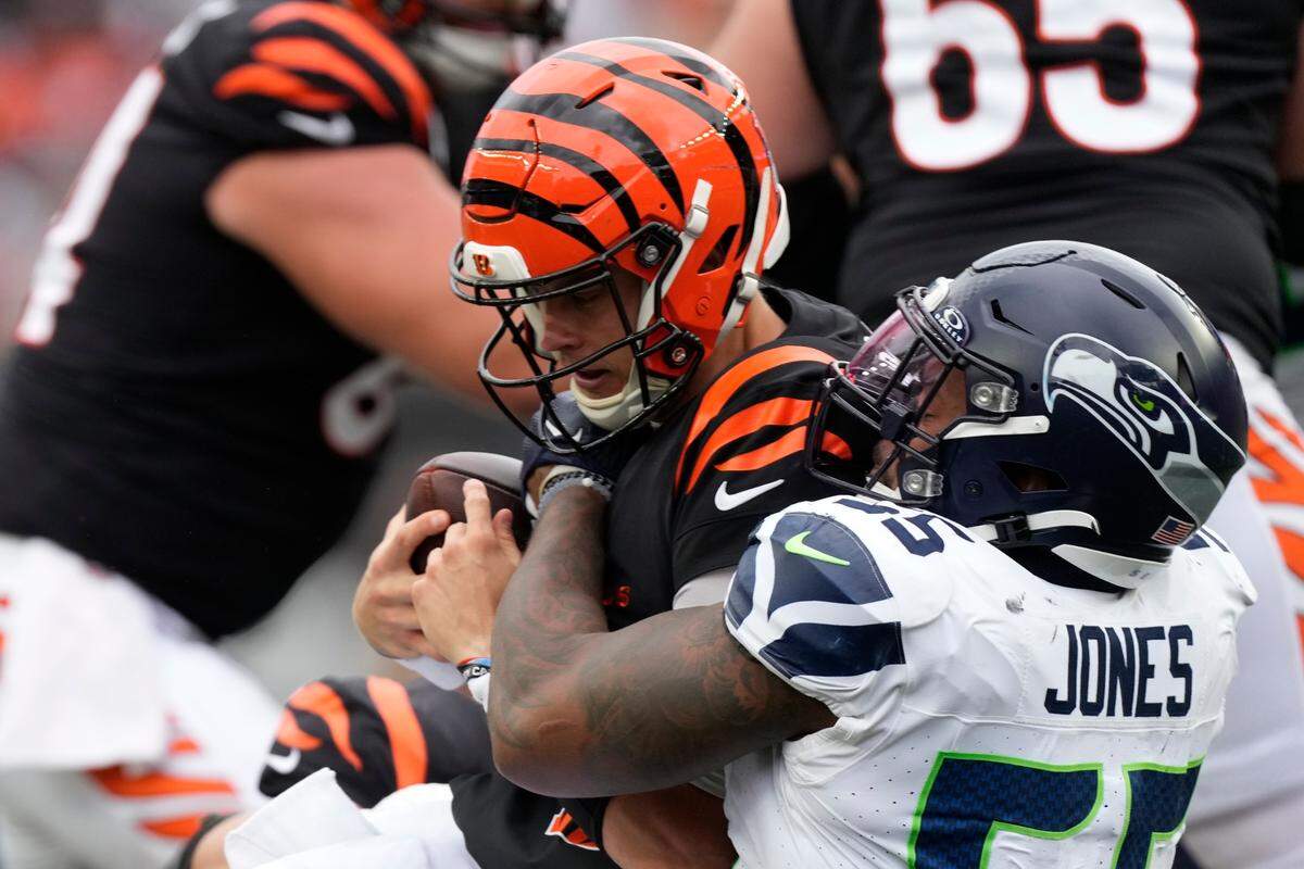 Cincinnati Bengals quarterback Joe Burrow (9) is sacked by Seattle Seahawks’ Dre’Mont Jones (55) during the second half of an NFL football game, Sunday, Oct. 15, 2023, in Cincinnati. (AP Photo/Carolyn Kaster)