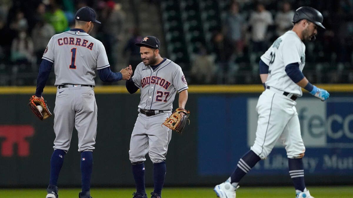 Houston Astros shortstop Carlos Correa (1) greets Houston Astros second baseman Jose Altuve (27) as Seattle Mariners catcher Luis Torrens walks away after being forced at second by Correa in the ninth inning to end the baseball game, Monday, Aug. 30, 2021, in Seattle. The Astros won 4-3. (AP Photo/Ted S. Warren)