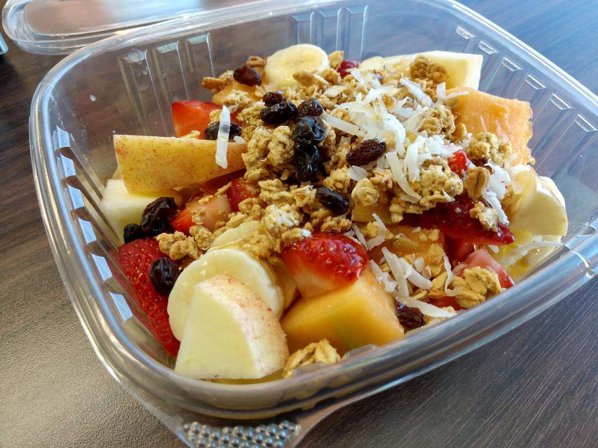 Escamocha, a container of fresh-cut fruit coated in honey, raisins and shredded coconut from La Casa de Sharon.