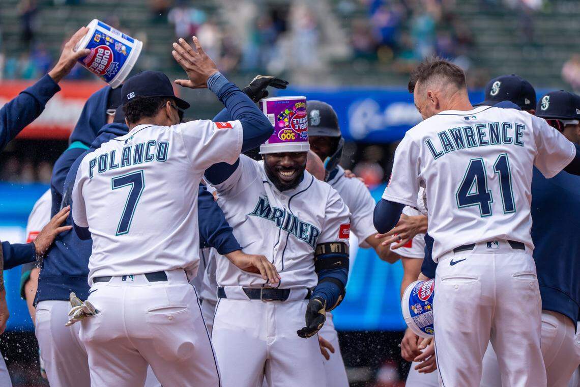 Apr 9, 2025; Seattle, Washington, USA;  Seattle Mariners left fielder Randy Arozarena (56), center, celebrates with designated hitter Jorge Polanco (7) and relief pitcher Casey Lawrence (41) after a game against the Houston Astros at T-Mobile Park. Mandatory Credit: Stephen Brashear-Imagn Images