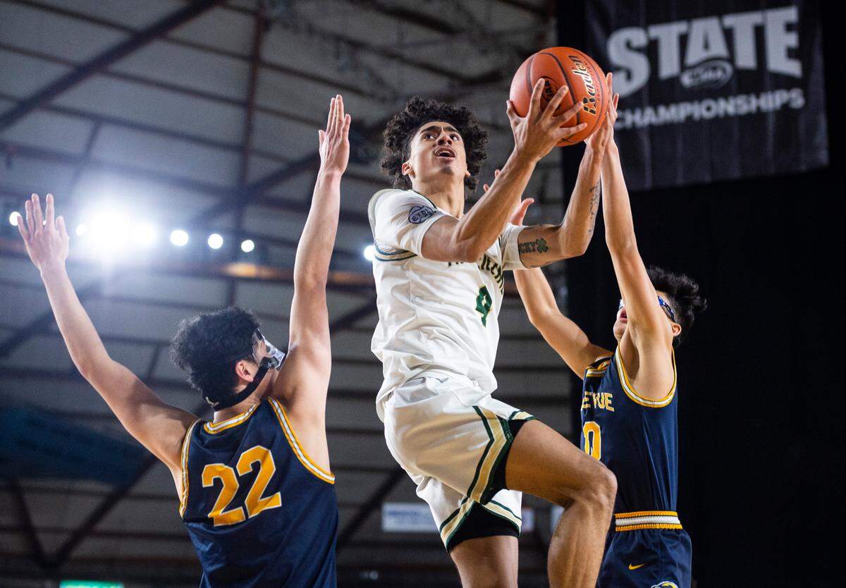 Timberline guard Brooklyn Hicks (4) goes in for a layup as Bellevue guard Brady Kageyama (10) tries to block him during an opening round game at the WIAA state basketball tournament in the Tacoma Dome in Tacoma, Washington, on Wednesday, March 1, 2023. Timberline lost the game 49-52.