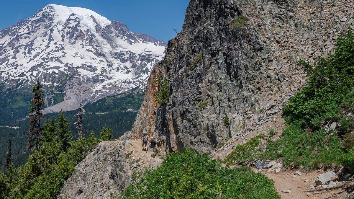 Two hikers descend the Pinnacle Saddle Trail at Mount Rainier National Park in July 2024. Some people fear federal funding cuts could jeopardize access to national park trails.