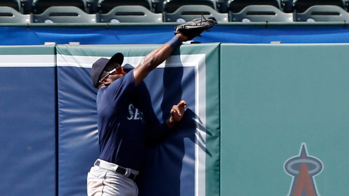 Seattle Mariners left fielder Denard Span leaps at the fence to catch Los Angeles Angels’ Andrelton Simmons RBI sacrifice fly ball, to score Justin Upton, during the seventh inning of a baseball game in Anaheim, Calif., Sunday, July 29, 2018. (AP Photo/Alex Gallardo)