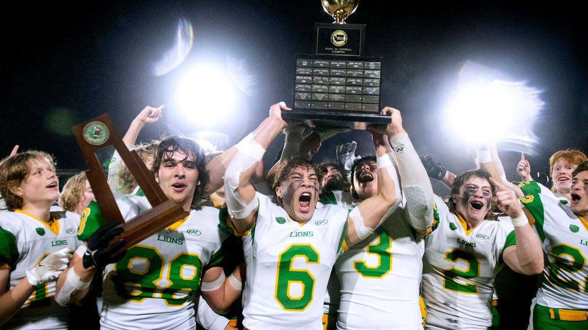 The Lynden Lions celebrate their 2A football state championship win over the Tumwater T-Birds, 21-7, at Sparks Stadium in Puyallup, Washington, on Saturday, Dec. 4, 2021.