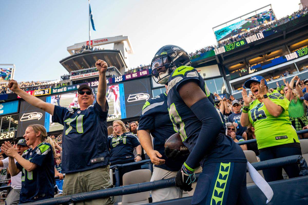 Seattle Seahawks cornerback Tariq Woolen (27) celebrates with fans in the front row after recovering a fumble by Arizona Cardinals quarterback Kyler Murray (1) during the third quarter of an NFL game on Sunday, Oct. 16, 2022, at Lumen Field in Seattle.