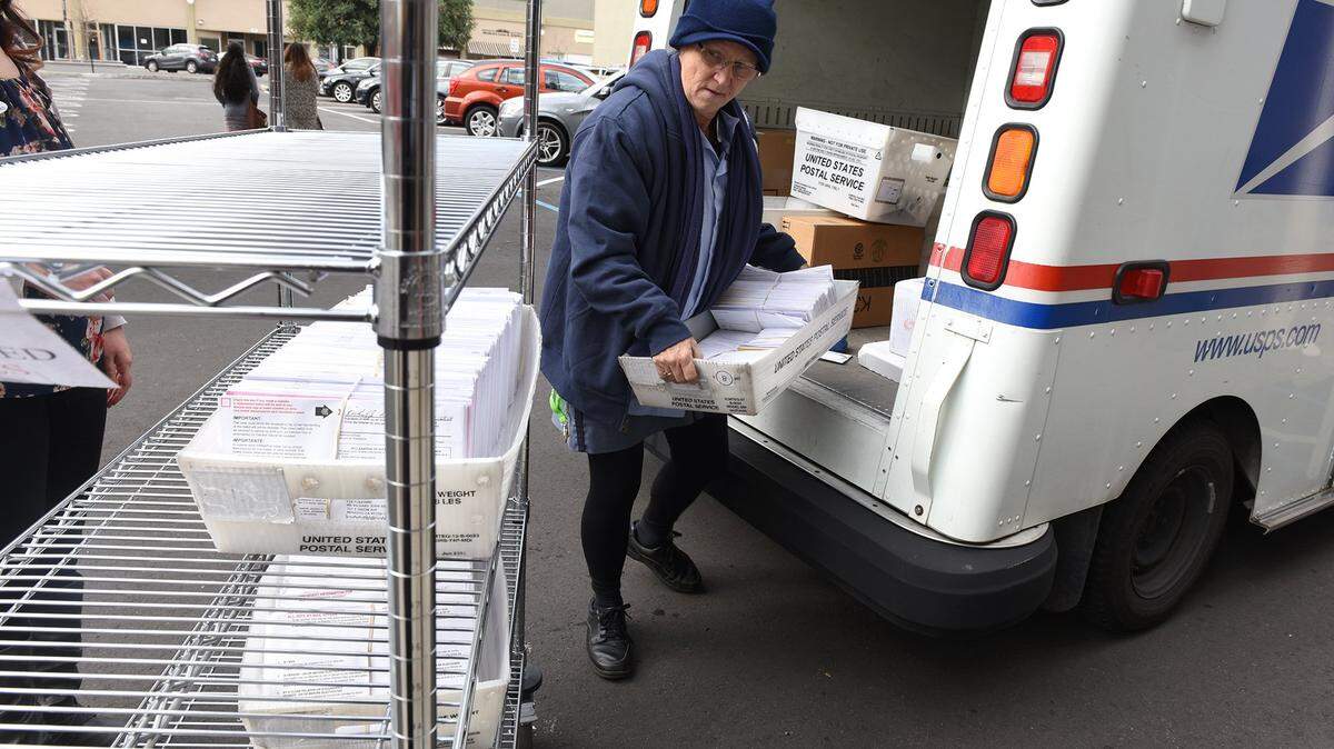 Postal Service carrier Rhonda Parker unloads vote-by-mail ballots at the Stanislaus County elections office in Modesto in February 2016.