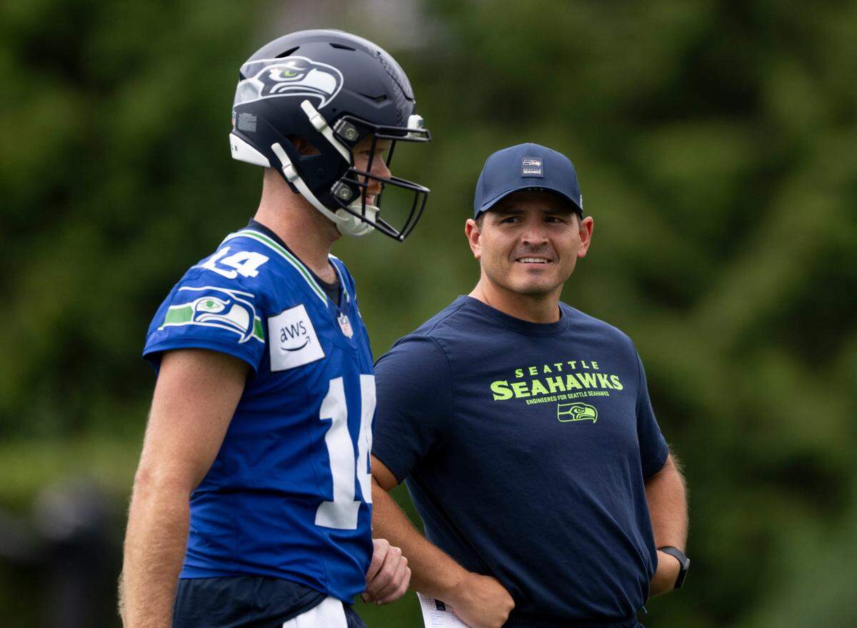 Seattle Seahawks quarterback Sam Darnold (14) and head coach Mike Macdonald talk during training camp at Virginia Mason Athletic Center on Friday, July 25, 2025, in Renton.