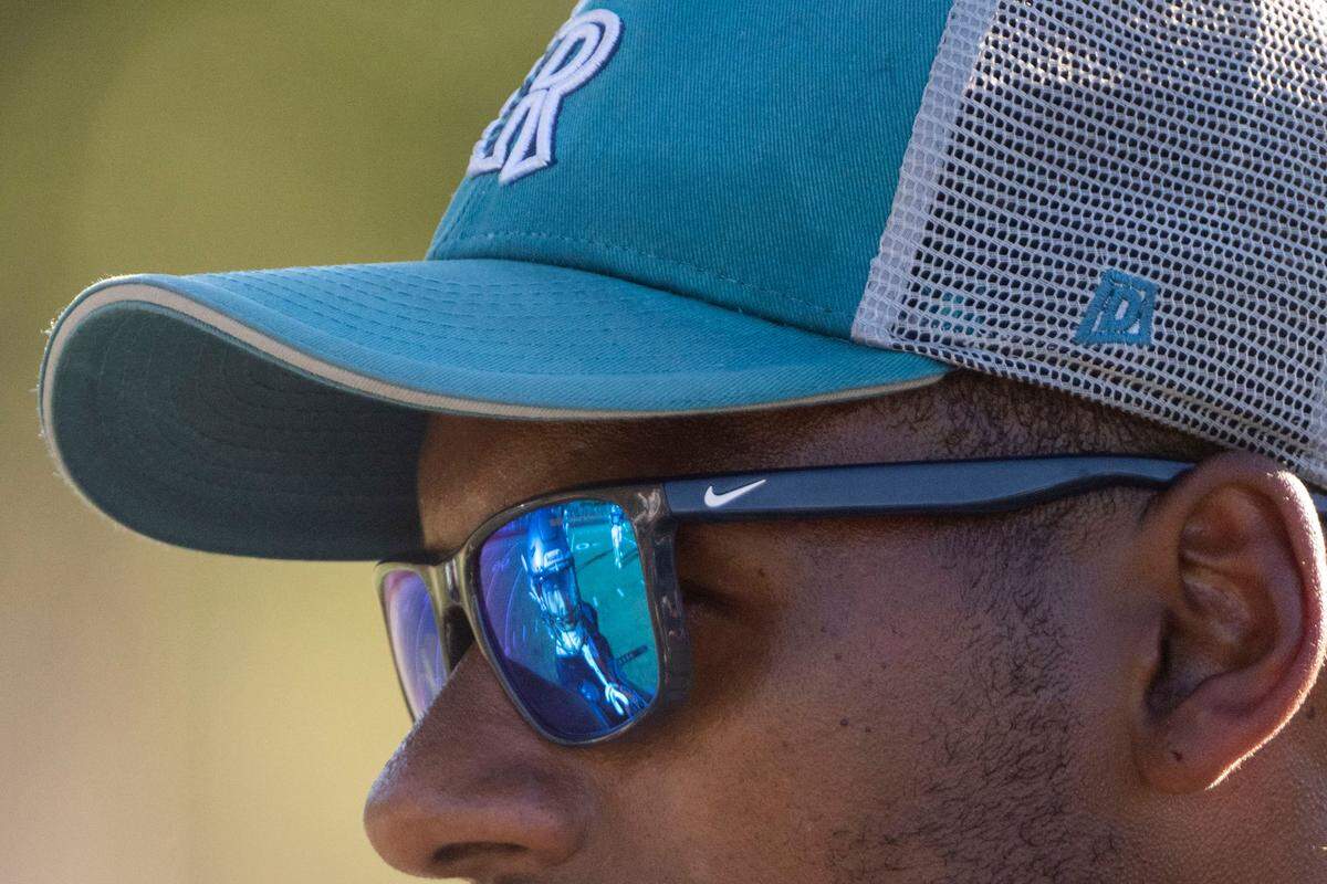 A player is seen in the reflection in the sunglasses of Auburn Riverside head coach Greg Herd during practice on Monday, Aug. 22, 2022, at Auburn-Riverside High School in Auburn, Wash.