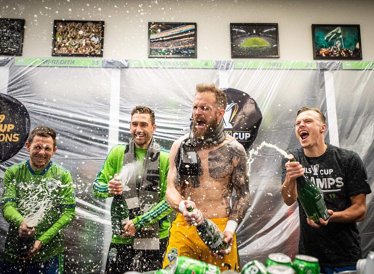 Seattle Sounders forward Harrison Shipp, Seattle Sounders defender Jonathan Campbell, Seattle Sounders goalkeeper Stefan Frei, and Seattle Sounders defender Brad Smith spray Heineken in celebration after the match. The Seattle Sounders FC played Toronto FC during the MLS Cup at CenturyLink Field in Seattle, Wash., on Sunday, Nov. 10, 2019.