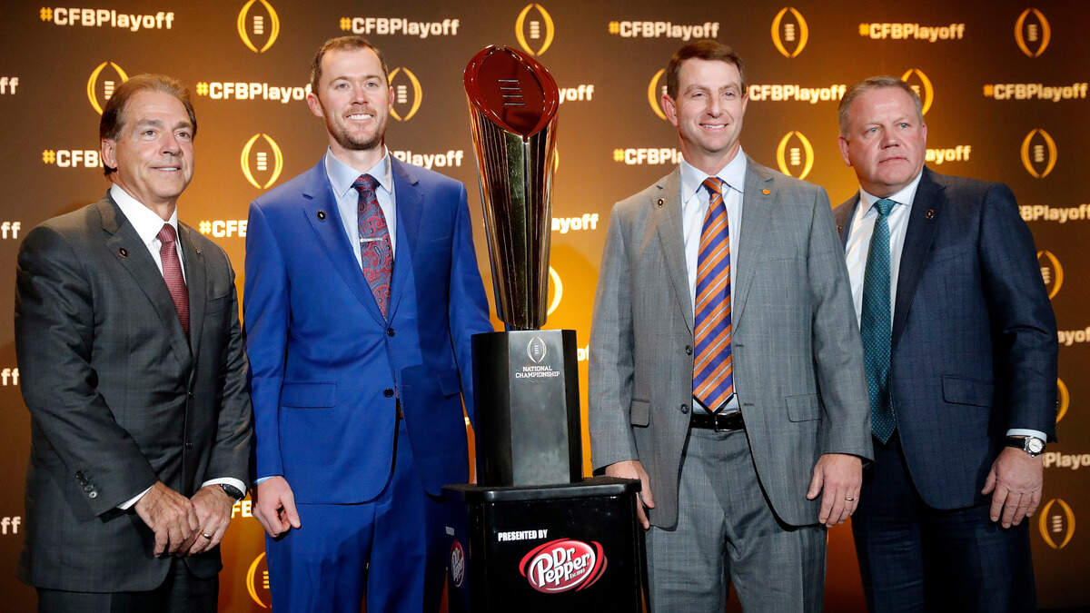 Football coaches Nick Saban, of Alabama; Lincoln Riley, of Oklahoma; Dabo Swinney, of Clemson; and Brian Kelly, of Notre Dame, from left, pose with the college football championship trophy after a news conference Thursday, Dec. 6, 2018, in Atlanta. The four teams are in the College Football Playoff. (AP Photo/John Bazemore)