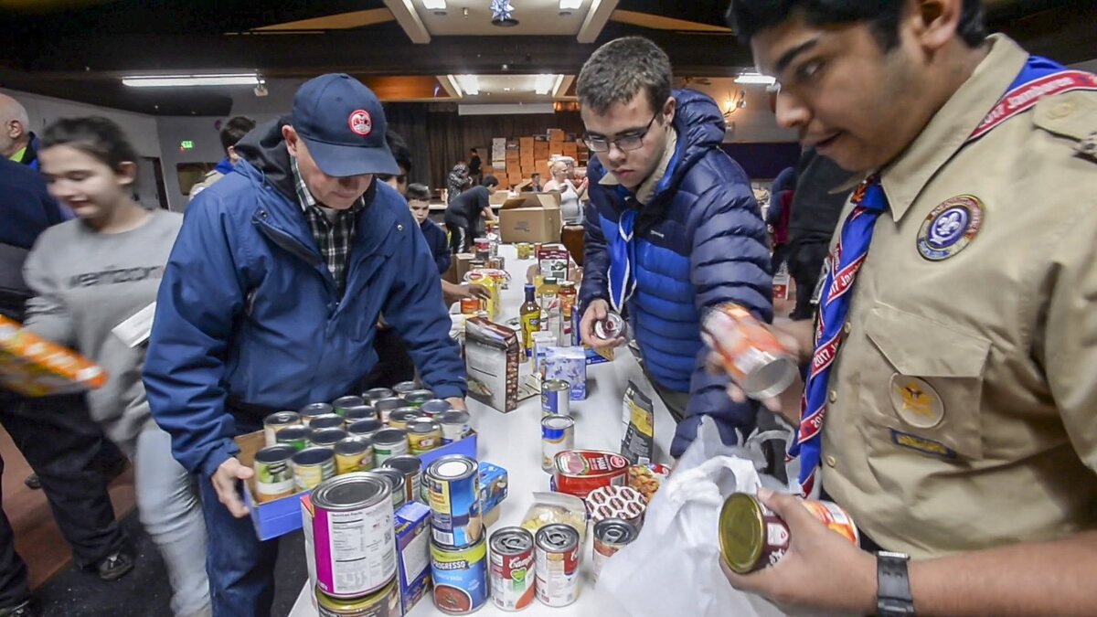 Scores of scouts and other volunteers organize food at the Puyallup Elks Club for the annual Christmas Basket Program, December 10, 2018.