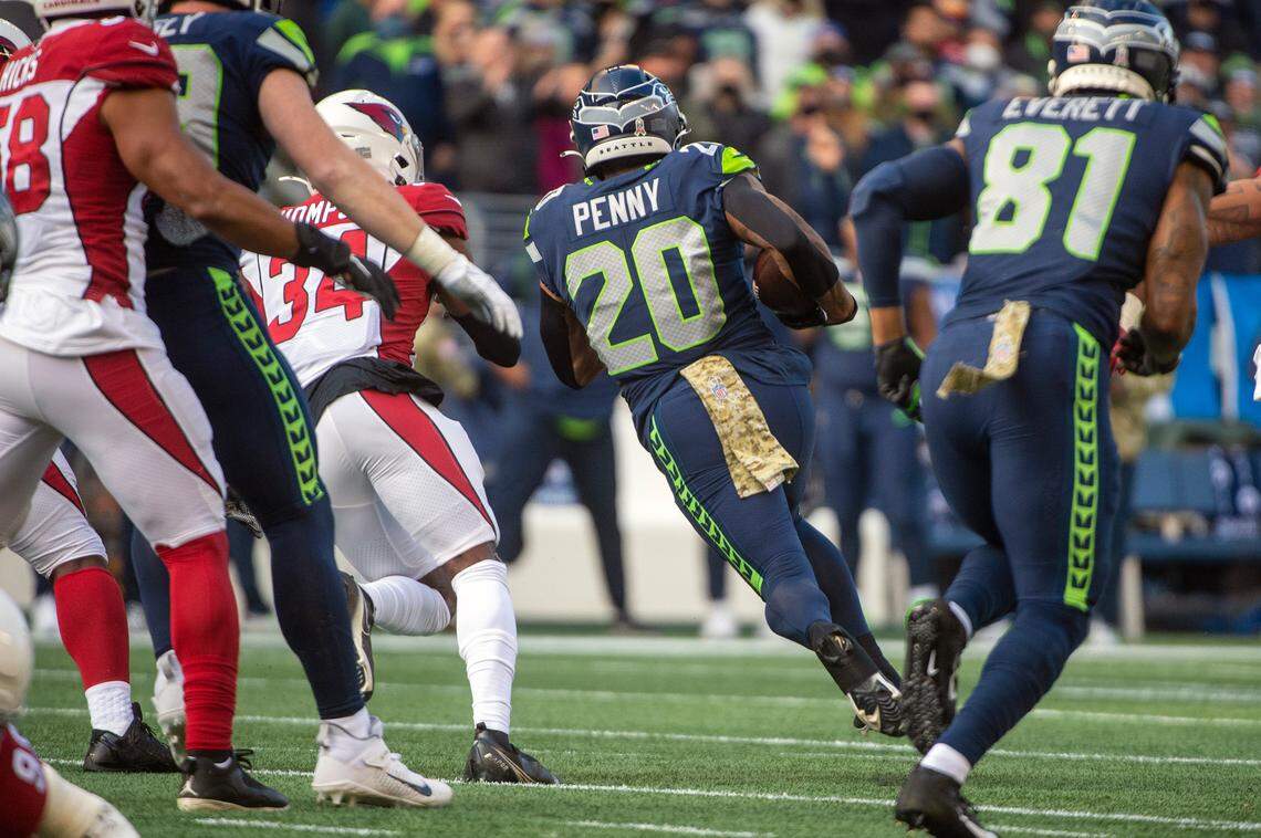 Seattle Seahawks running back Rashaad Penny (20) carries the ball as Arizona Cardinals free safety Jalen Thompson (34) looks to track him down during the first quarter of an NFL game on Sunday afternoon at Lumen Field in Seattle.