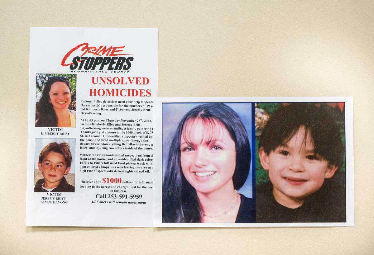 Images of Kimberly Riley, 19, left, and Jeremy Britt-Bayinthavong, 5, right, hang on a wall during an on-camera briefing asking people to come forward with information regarding their unsolved murders that occurred in 2002 on Thanksgiving after a shooting at a home in Tacoma’s South End, at the Tacoma Police Department Headquarters in Tacoma, Wash. on Nov. 3, 2022.