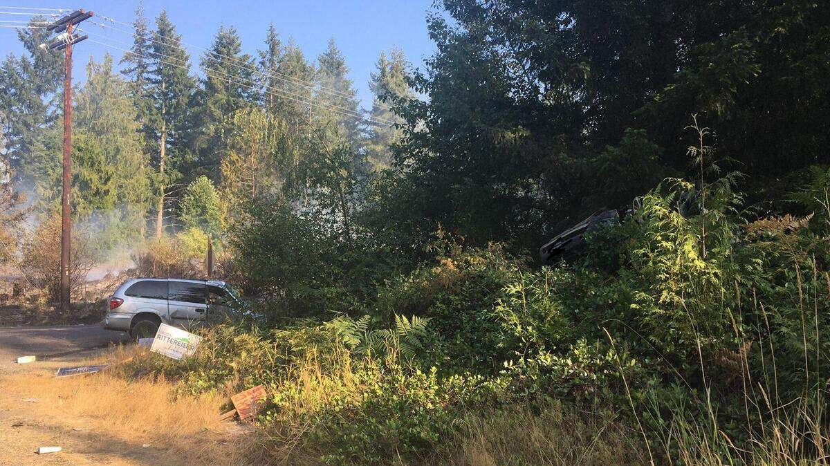 An overturned SUV sits in the bushes after it was T-boned by a minivan that ran a stop sign Monday afternoon on state Route 702 east of McKenna, according to the Washington State Patrol. Three occupants in the SUV died at the scene of the wreck, and the minivan sparked a 10-acre brush fire that was later knocked down.