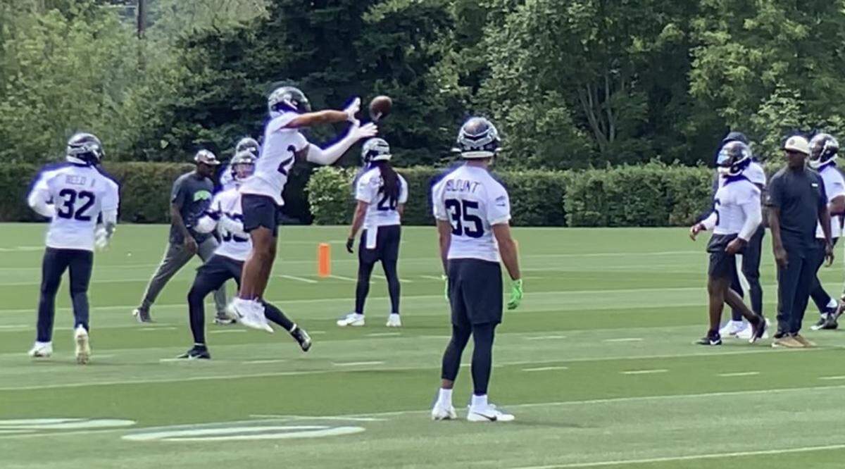 New safety Julian Love (20) in a defensive-backs reaction drill at Seahawks minicamp June 7, 2023, at the Virginia Mason Athletic Center in Renton. Pro Bowl safety Quandre Diggs (6) is watching Love’s catch at the far right.