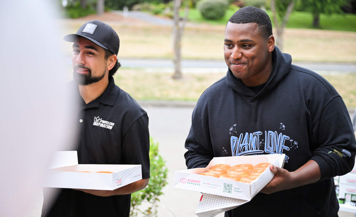 John “PUSH” Gaines hands out doughnuts and welcomes students on the first day of school at Gray Middle School, on Monday, Sept. 9, 2024, in Tacoma, Wash.