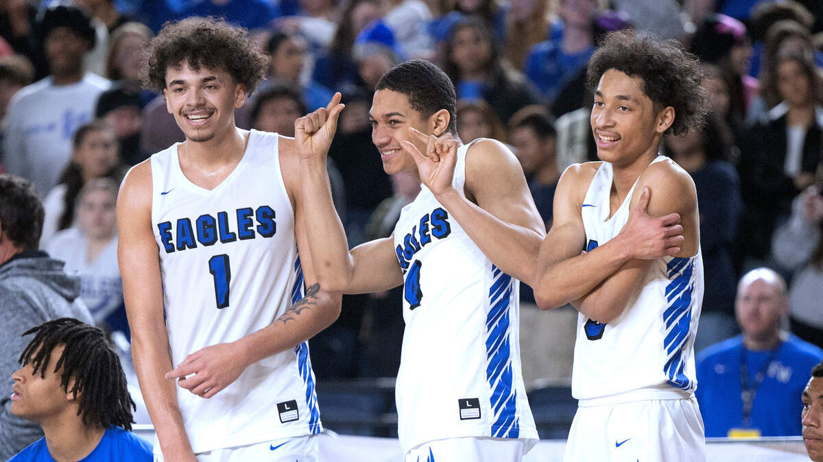 Federal Way starters Dace Pleasant (from left), Kofi Peyton and Dane Lewis celebrate on the bench late in the Eagles’ state quarterfinal game against the Skyline Spartans at the WIAA state basketball tournament in the Tacoma Dome in Tacoma, Washington, on Wednesday, March 1, 2023. Federal Way won the game, 69-53.