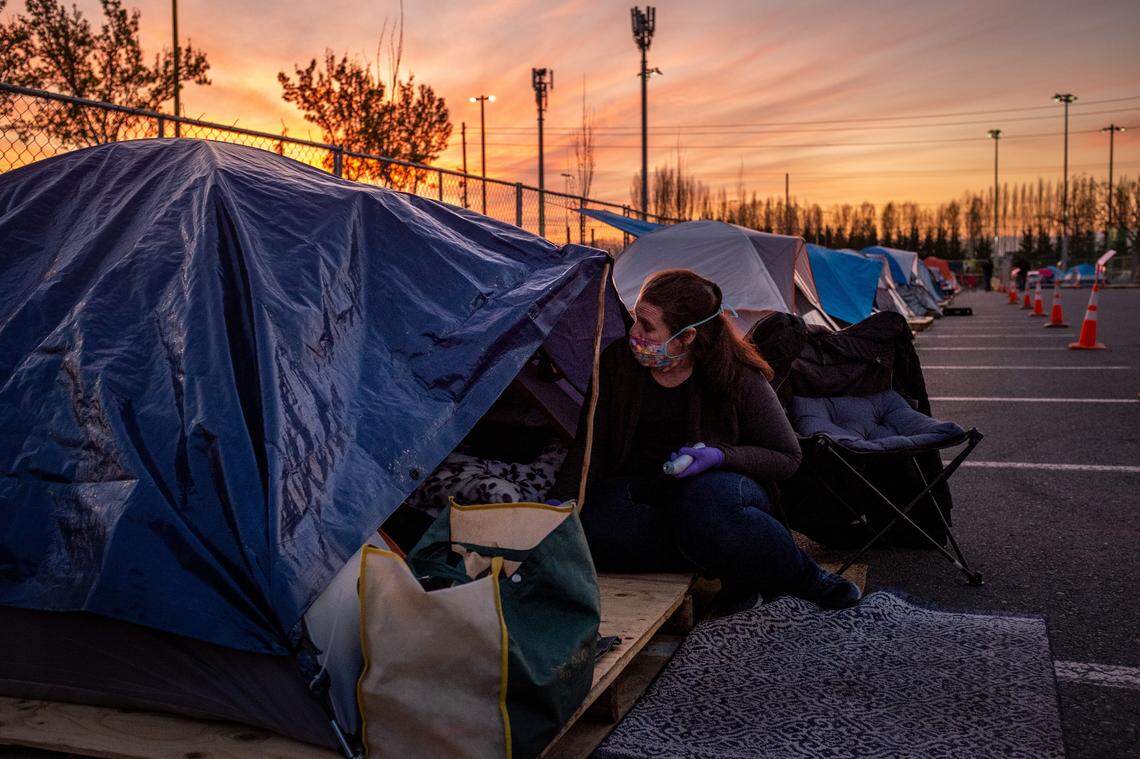 Anne Papoff-Wallace checks on a person experiencing homelessness at a temporary homeless camp set up in Puyallup on April 7, 2020.