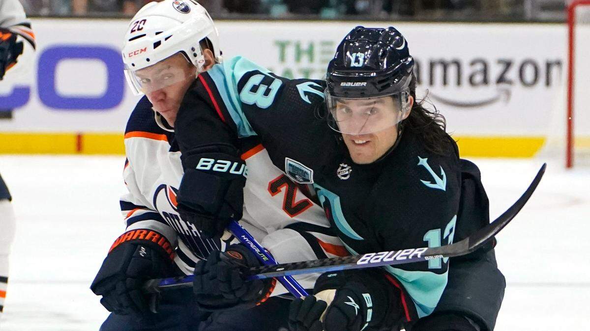 Seattle Kraken’s Brandon Tanev right, and Edmonton Oilers’ Slater Koekkoek become entangled as they chase the puck in the first period of an NHL hockey game Saturday, Dec. 18, 2021, in Seattle. (AP Photo/Elaine Thompson)