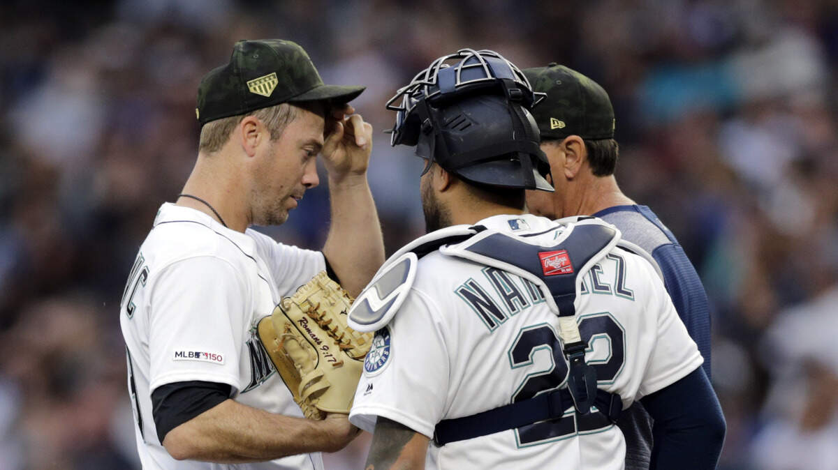 Seattle Mariners starting pitcher Wade LaBlanc, left, talks on the mound with catcher Omar Narvaez and pitching coach Paul Davis during the second inning against the Minnesota Twins in a baseball game Saturday, May 18, 2019, in Seattle.