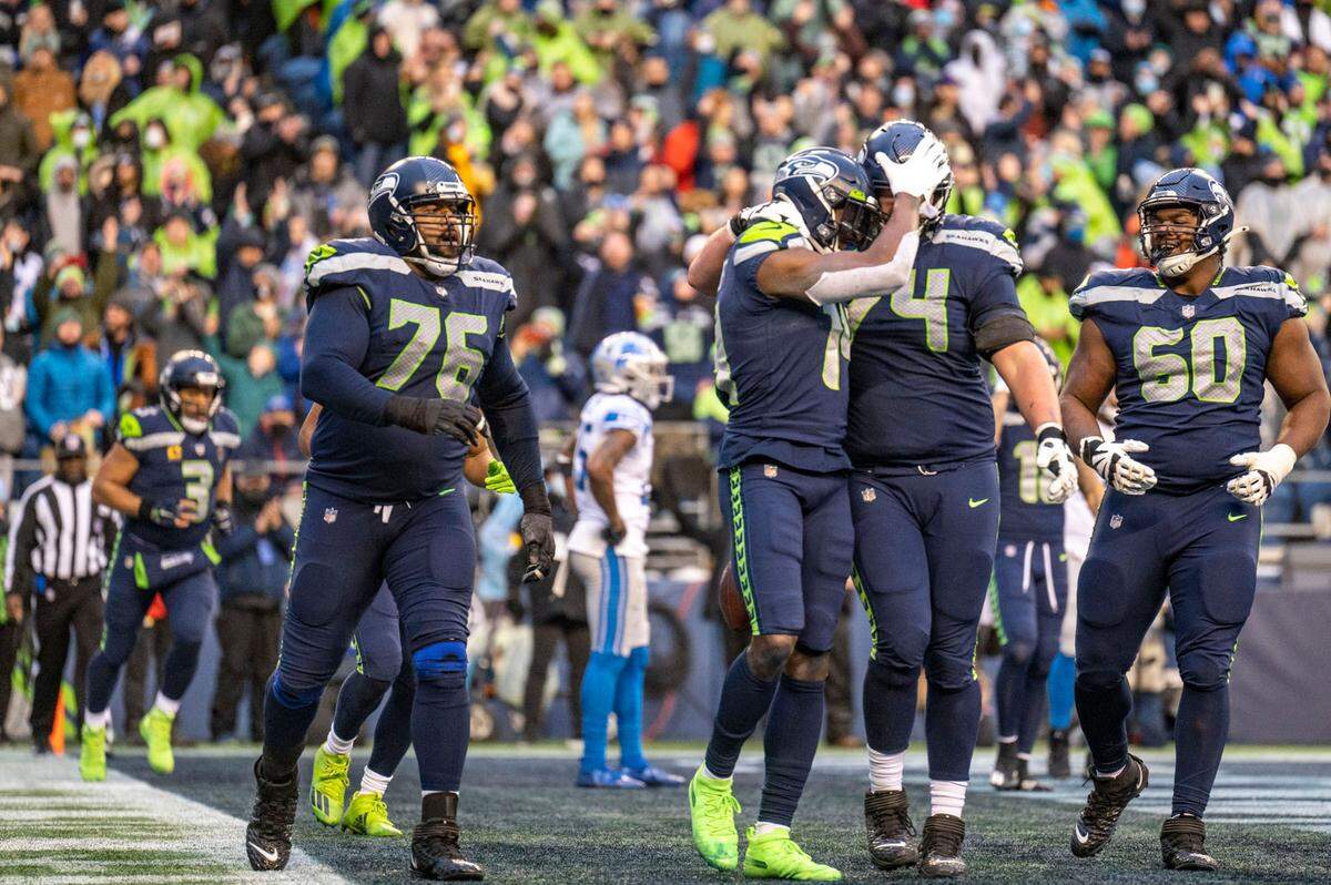 Seattle Seahawks wide receiver DK Metcalf (14) celebrates his third touchdown catch of the day with Seattle Seahawks offensive tackle Jake Curhan (74) during the fourth quarter of an NFL game on Sunday, Jan. 2, 2022, at Lumen Field in Seattle.