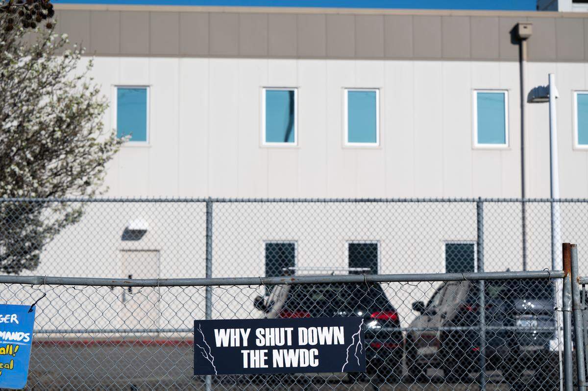 Signs hanging from the outer fence of the Northwest Ice Processing Center demand that the facility be shutdown in Tacoma, Wash., on Tuesday, March 19, 2024.