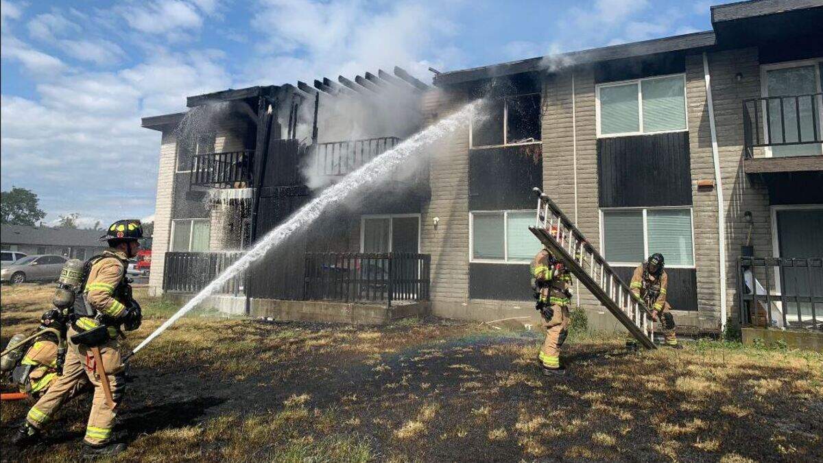 Firefighters extinguish an apartment fire Wednesday afternoon in the 4800 block of 121st Street SW in Lakewood. 