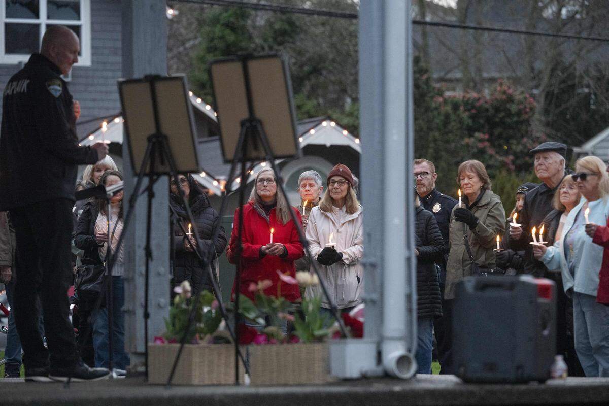 Gig Harbor Police chaplain Gary Rudd, left, leads a moment of silence with those gathered for a candlelight vigil for the victims of last month's stabbing attack on Wednesday, March 4, 2026, at Skansie Brothers Park in Gig Harbor, Wash.