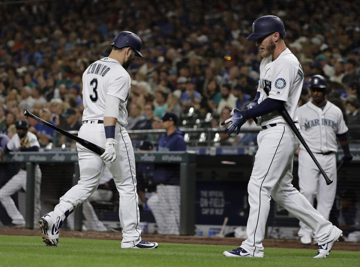 Seattle Mariners’ Mike Zunino (3) walks to the dugout after striking out with two men on base, as Chris Herrmann approaches the plate for an at-bat during the eighth inning of a baseball game against the Toronto Blue Jays, Saturday, Aug. 4, 2018, in Seattle. (AP Photo/Ted S. Warren)