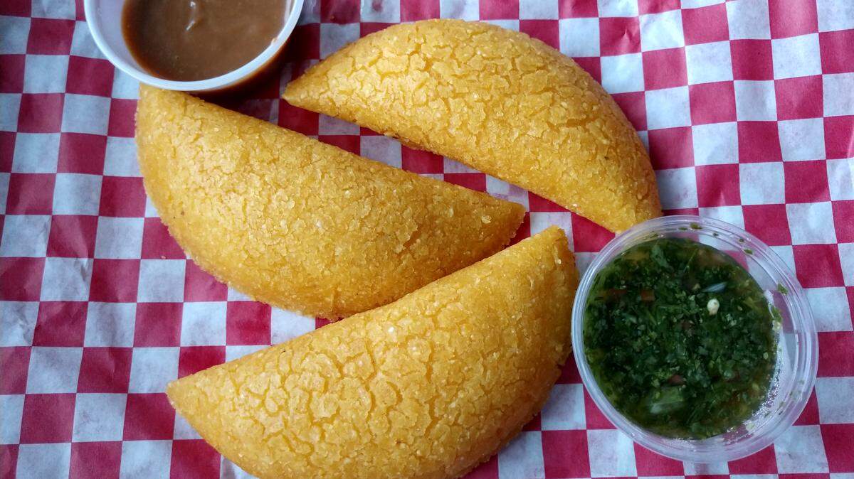 Cheese empanadas come with cilantro aji sauce and arequipe, a carmel sauce, at Sabor Colombiano Luis Panes Empanadas in Tacoma.
