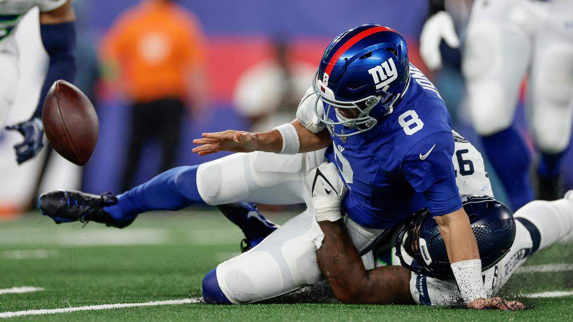 New York Giants quarterback Daniel Jones (8) fumbles the ball as he is tackled by Seattle Seahawks defensive end Mario Edwards Jr. (97) during the second quarter of an NFL football game, Monday, Oct. 2, 2023, in East Rutherford, N.J. (AP Photo/Adam Hunger)