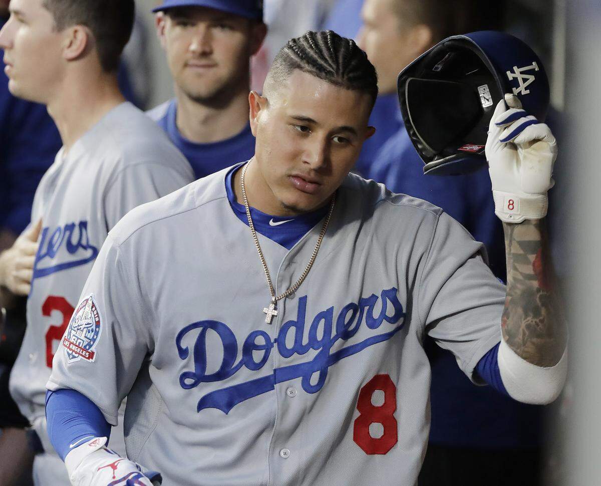 Los Angeles Dodgers’ Manny Machado takes off his batting helmet in the dugout after he hit a solo home run against the Seattle Mariners during the fourth inning of a baseball game Friday, Aug. 17, 2018, in Seattle. (AP Photo/Ted S. Warren)