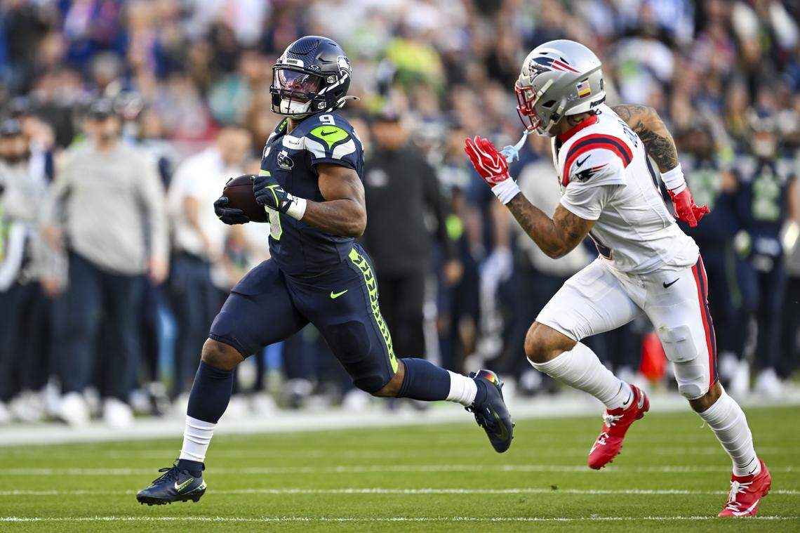 Seattle Seahawks running back Kenneth Walker III (9) carries the ball up field as New England Patriots cornerback Christian Gonzalez (0) looks to make a tackle during the second quarter of Super Bowl LX at Levi's Stadium on Feb. 8, 2026 in Santa Clara, Calif.