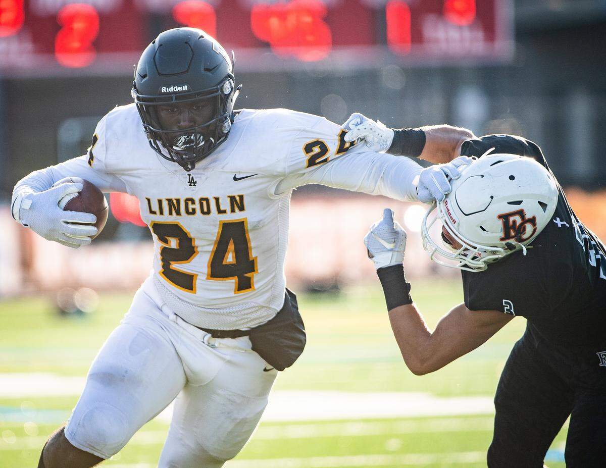 Lincoln’s Julien Simon stiff-arms Eastside Catholic’s Everette Isaac during the first quarter. Lincoln played Eastside Catholic in the 3A football semifinal game at Sammamish High School in Bellevue, Wash., on Saturday, Nov. 30, 2019.