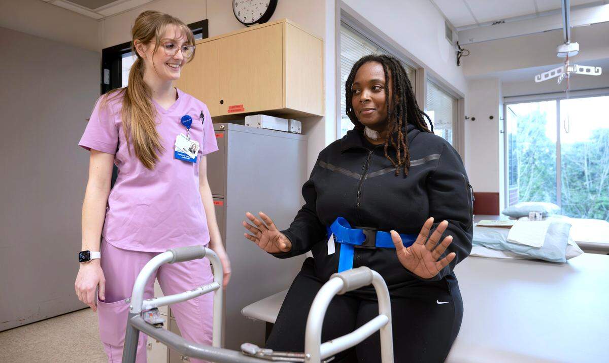 Physical therapist assistant Mary Hagen encourages Shaunece Yates of Seattle during their exercise gym session in the Rehabilitation Center at Good Samaritan Hospital in Puyallup, Washington, on Thursday, Dec. 12, 2024. “I’ve made a lot of progress really fast with their help,” she said of her rehabilitation after breaking her spine in a freak accident while playing with her two sons. “No more roughhousing for me,” she said.