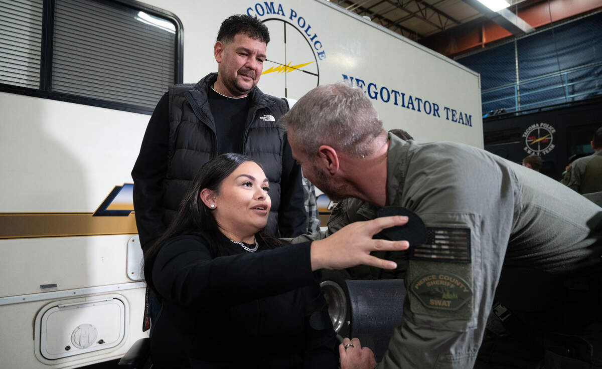 Domestic violence survivor “Selena” thanks Pierce County Sheriff’s SWAT team member Sgt. Bob Shaw during ceremonies at the Tacoma Police Department in Tacoma, Washington, on Thursday, Dec. 5, 2024. SWAT officers rescued Selena from a hostage situation with her ex-boyfriend in July, where Selena had been shot in the head.