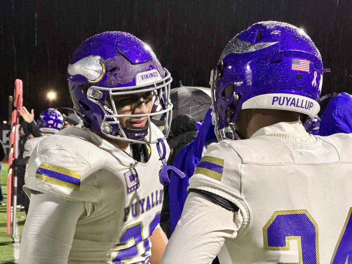 Puyallup linebacker Michael Pulalasi, left, talks with a teammate during Puyallup’s 4A SPSL championship win over Graham-Kapowsin at Art Crate Field in Spanaway, Wash. on Friday, Oct. 31, 2025.