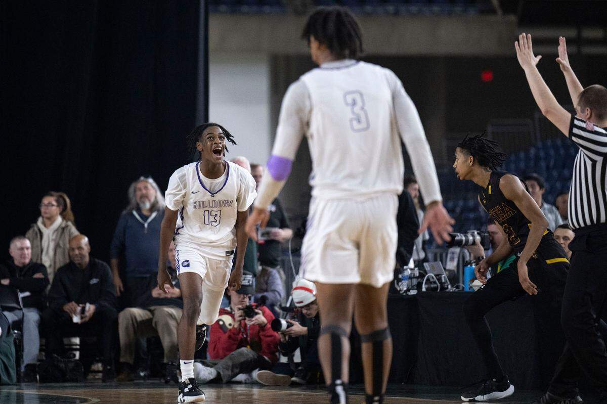 Garfield guard Legend Smiley (13) celebrates after making a 3-pointer from the corner as O’Dea guard Mason Williams (2) looks on during the fourth quarter of the Class 3A championship game on Saturday, March 4, 2023, in Tacoma, Wash.