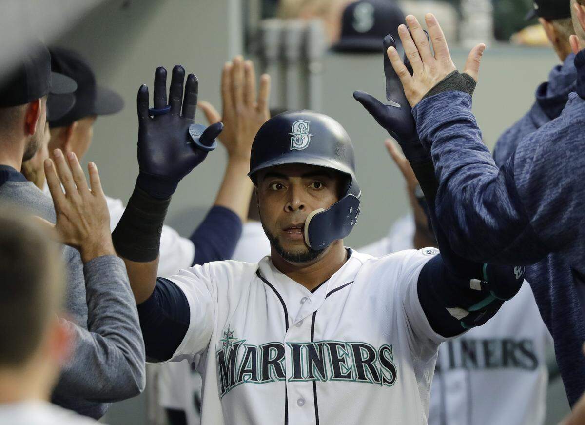 Seattle Mariners' Nelson Cruz is greeted in the dugout after he hit a two-run home run against the Oakland Athletics during the third inning of a baseball game Thursday, May 3, 2018, in Seattle. (AP Photo/Ted S. Warren)
