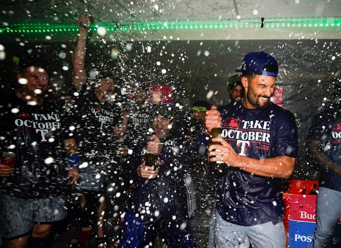 Texas Rangers second baseman Marcus Semien celebrates clinching a playoff spot in the American League with teammates after a 6-1 win over the Seattle Mariners in a baseball game, Saturday, Sept. 30, 2023, in Seattle. (AP Photo/Lindsey Wasson)