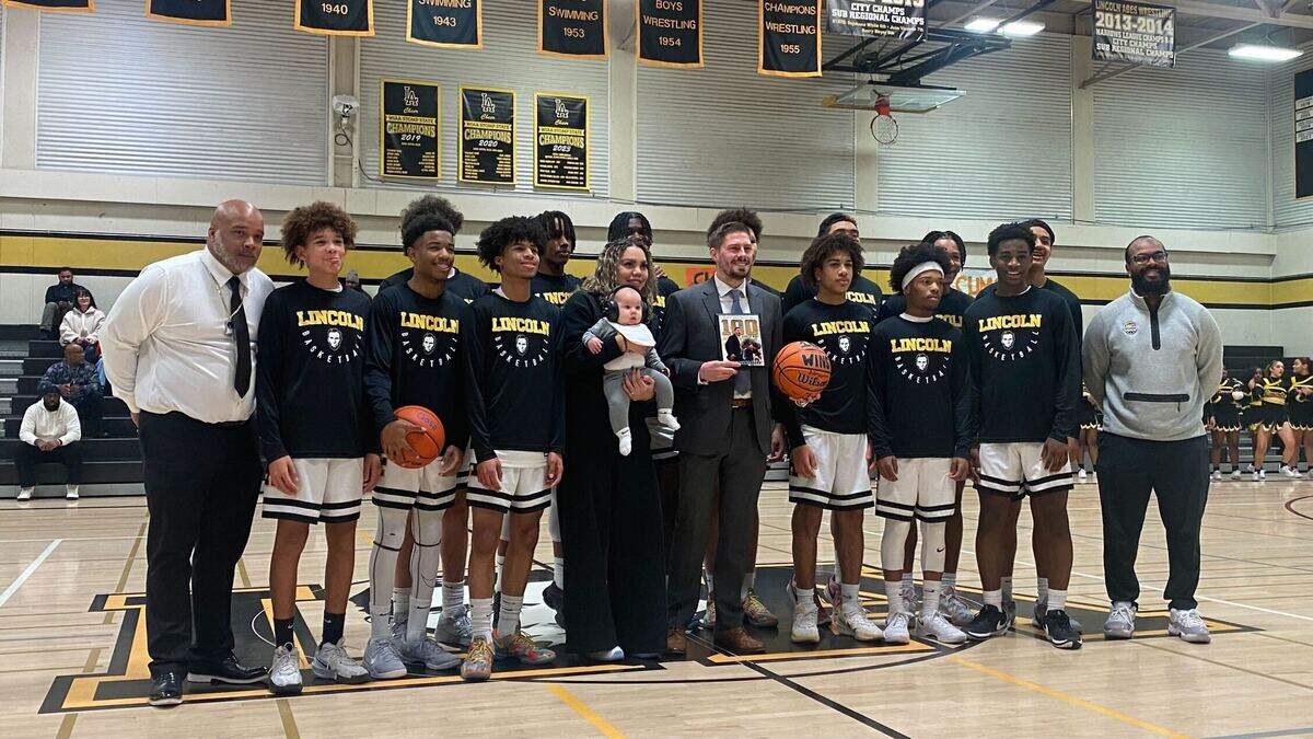 Lincoln head basketball coach Ryan Rogers (middle) is honored for his 100th career win ahead of Wednesday night’s game with River Ridge at Lincoln High School on Jan. 15, 2025, in Tacoma, Wash.