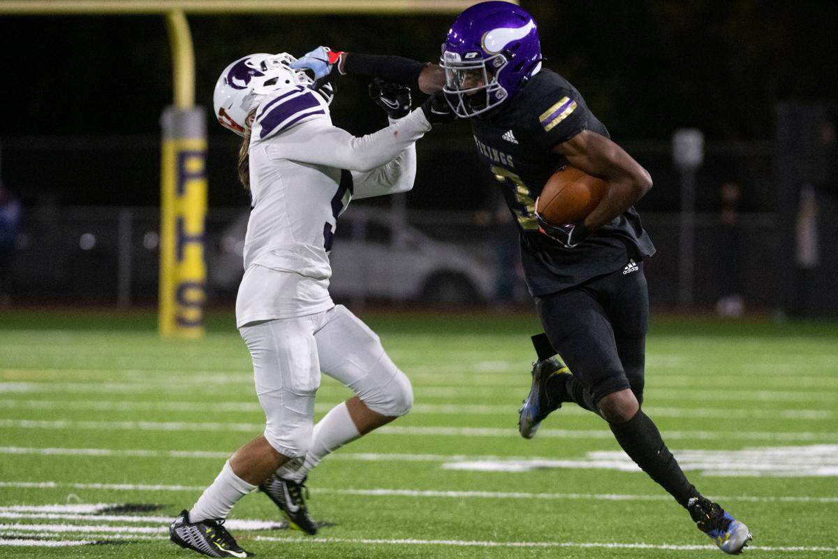 Puyallup receiver Mal Durant stiff arms Sumner’s Kade Jindra after catching a pass from quarterback Kaden Rolfsness during the third quarter of a 4A SPSL game on Friday, Sept. 23, 2022, at Sparks Stadium in Puyallup, Wash.